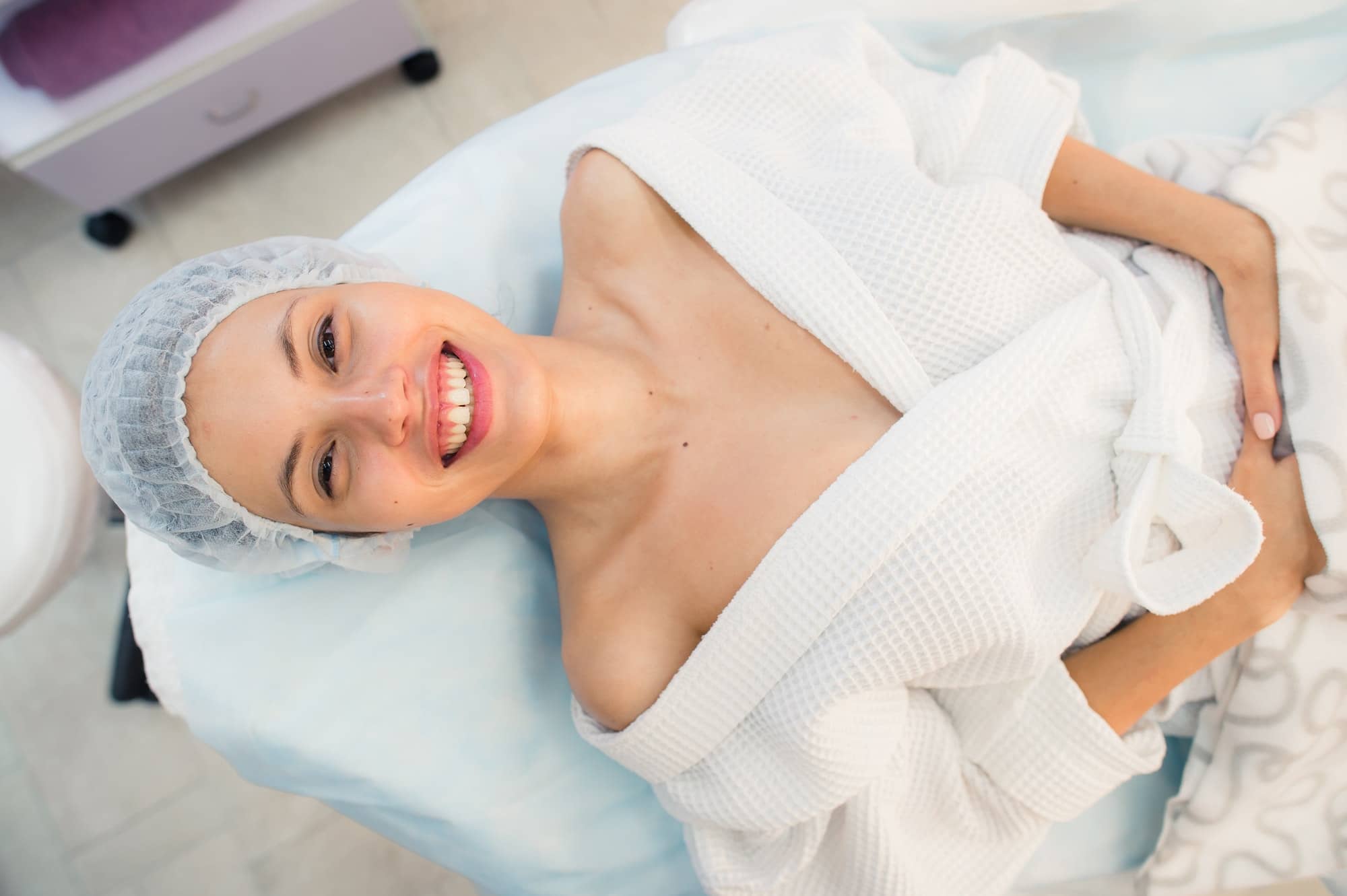 beautiful patient woman smile lying on bed in surgery room hospital